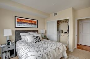 Woodinville apartment for rent - A bedroom with a large bed and a painting on the wall.