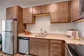 Milwaukee apartment for rent - A kitchen with brown cabinets and a white refrigerator.