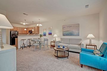 Fitchburg apartment for rent - A living room with a blue chair and a grey couch.