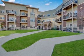 Fitchburg apartment for rent - Apartment complex with a walkway in the foreground.
