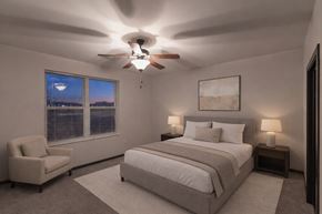 Deforest apartment for rent - A calm bedroom here at The Park with soft neutral bedding, matching nightstands with lamps, a cozy accent chair, and plush carpet, creating a peaceful, spacious, and inviting retreat.