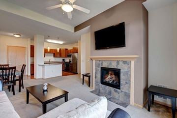 Sun Prairie apartment for rent - A living room with a fireplace and a television mounted above it.