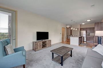 Fitchburg apartment for rent - A living room with a blue chair and a wooden coffee table.