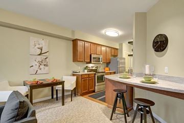 Shoreline apartment for rent - a kitchen with a bar and a living room with a table