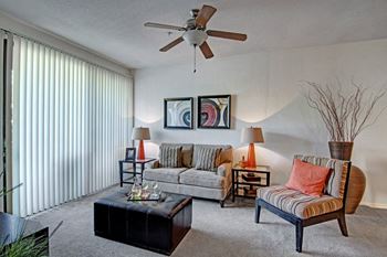 Acclaim apartments- furnished living room with patio/balcony access 