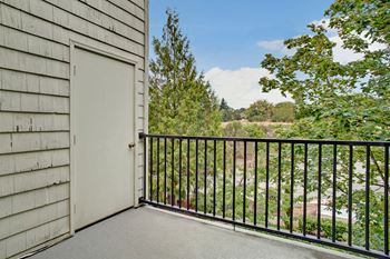 Balcony looking through trees with a door to the storage space