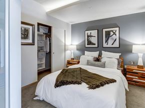 Seattle apartment for rent - A bedroom with a large bed and a green throw blanket.