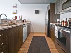 Seattle apartment for rent - A modern kitchen with dark wood cabinets and stainless steel appliances.