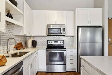 Minneapolis apartment for rent - A modern kitchen with white cabinets and stainless steel appliances.