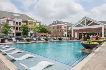 Resort-style pool with tanning ledge, in-water seating, and large sundeck
