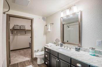 Bathrooms with garden tub, curved shower rod, and linen closets