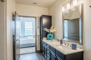 Bathrooms with garden tub, curved shower rod, and linen closets