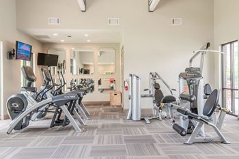 24-Hour fitness studio with cardio equipment, free weights, resistance & circuit training, and yoga balls