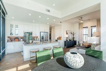 Austin apartment for rent - A modern living room with a grey sofa and green chairs.