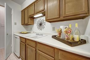 Midland apartment for rent - A kitchen with wooden cabinets and a white counter.