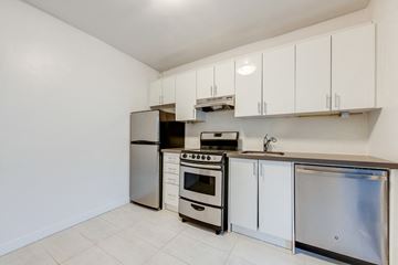 York apartment for rent - A kitchen with white cabinets and stainless steel appliances.