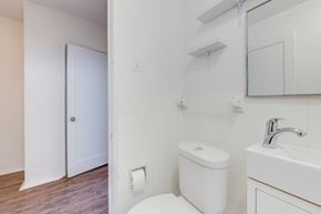York apartment for rent - A white toilet sits next to a white sink in a bathroom.