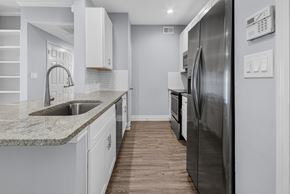 Corpus Christi apartment for rent - A modern kitchen with a stainless steel refrigerator and a marble countertop.