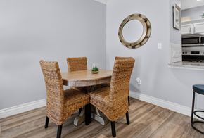 Corpus Christi apartment for rent - A dining room with a round mirror and a table with four chairs.