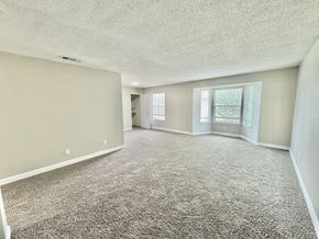 Corpus Christi apartment for rent - Large living room with grey carpet and bright natural light at Greenbriar Place 55+ Senior Apartments in Corpus Christi.