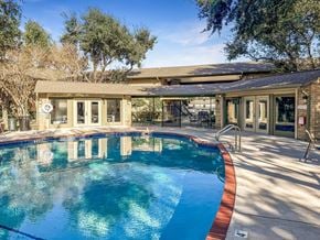 Corpus Christi apartment for rent - Relaxing swimming pool area at Greenbriar Place 55+ Apartments in Corpus Christi, featuring lounge chairs and landscaped surroundings.