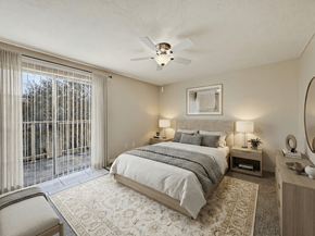 Brownsville apartment for rent - A bedroom with a large bed, a chair, and a ceiling fan.