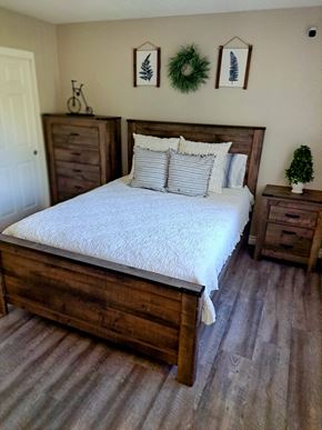 Highland apartment for rent - A bedroom with a large bed and a small tree on the nightstand at Raintree Apartments, CA 92346