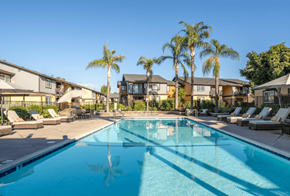 Highland apartment for rent - A swimming pool surrounded by palm trees and lounge chairs at Raintree Apartments, CA 92346