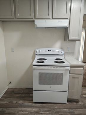 Yucaipa apartment for rent - A white stove in a kitchen with wooden floors.