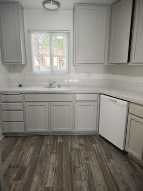 Yucaipa apartment for rent - A kitchen with white cabinets and a wooden floor.