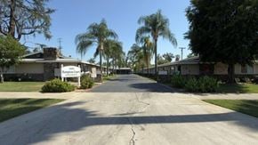 Redlands apartment for rent - A street view of a residential area with houses and palm trees.