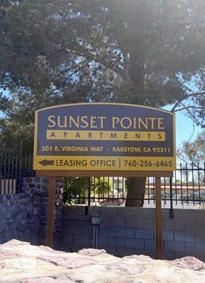 Barstow apartment for rent - A sign for Sunset Pointe Apartments with a leasing office phone number.