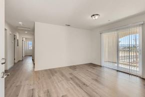 San Bernardino apartment for rent - A spacious room with wooden flooring and white walls.