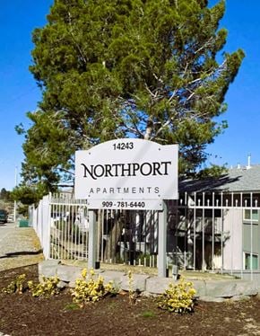 Victorville apartment for rent - A sign for Northport Apartments is displayed in front of a tree.