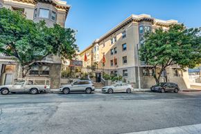Los Angeles apartment for rent - a city street with cars parked on the side of the road and a building in the background