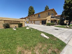 Fontana apartment for rent - A yellow house with a garage and a driveway in front.