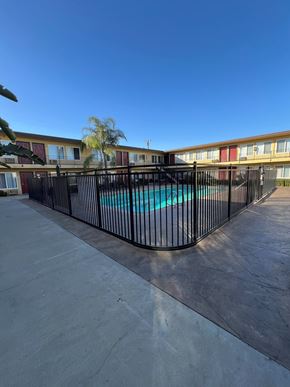 Ontario apartment for rent - A pool surrounded by a black fence in front of a building.