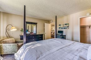 Upland apartment for rent - A bedroom with a large bed, a dresser, and a chair.
