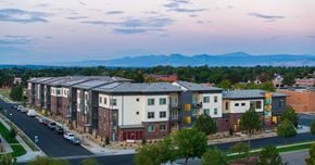 Longmont apartment for rent - A street view of a residential area with apartment buildings and cars parked on the side of the road.