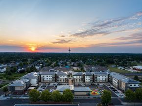 Longmont apartment for rent - A sunset view of a town with a large building in the foreground.