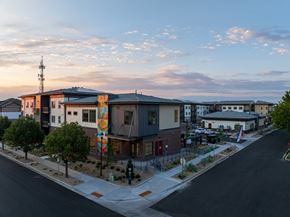 Longmont apartment for rent - A street view of a modern building with a colorful mural on the side.