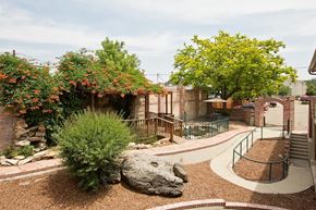 Longmont apartment for rent - A garden with a large rock in the center and a metal fence surrounding it.