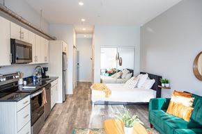 Pittsburgh apartment for rent - a bedroom with a bed and a kitchen and a living room
