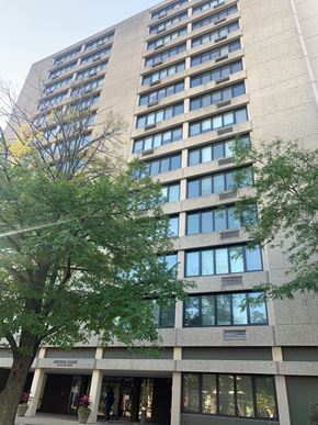 Oak Park apartment for rent - A tall building with many windows and a tree in front.