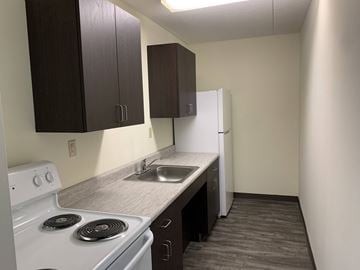 Springfield apartment for rent - A kitchen with a white stove and dark brown cabinets.