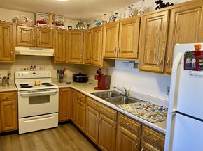 Pekin apartment for rent - A kitchen with wooden cabinets and a white refrigerator.