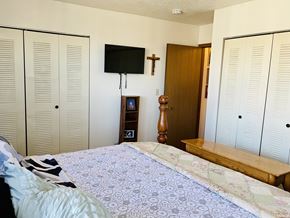 Pekin apartment for rent - A bedroom with a bed, a TV, and a cross on the wall.