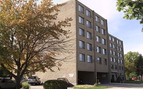 Urbana apartment for rent - A large building with a parking lot in front.