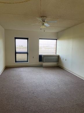Taylorville apartment for rent - an empty room with a ceiling fan and two windows