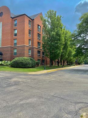 Naperville apartment for rent - A red brick building with a green lawn in front.